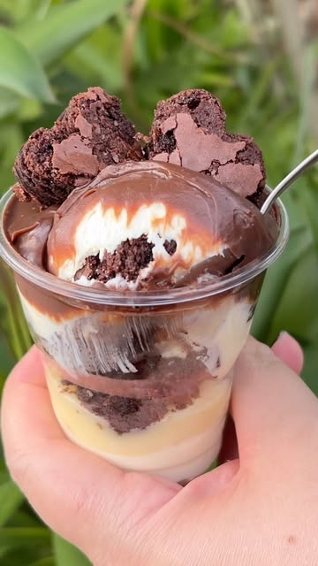 Copo de sobremesa com camadas de creme, calda de chocolate e pedaços de brownie
